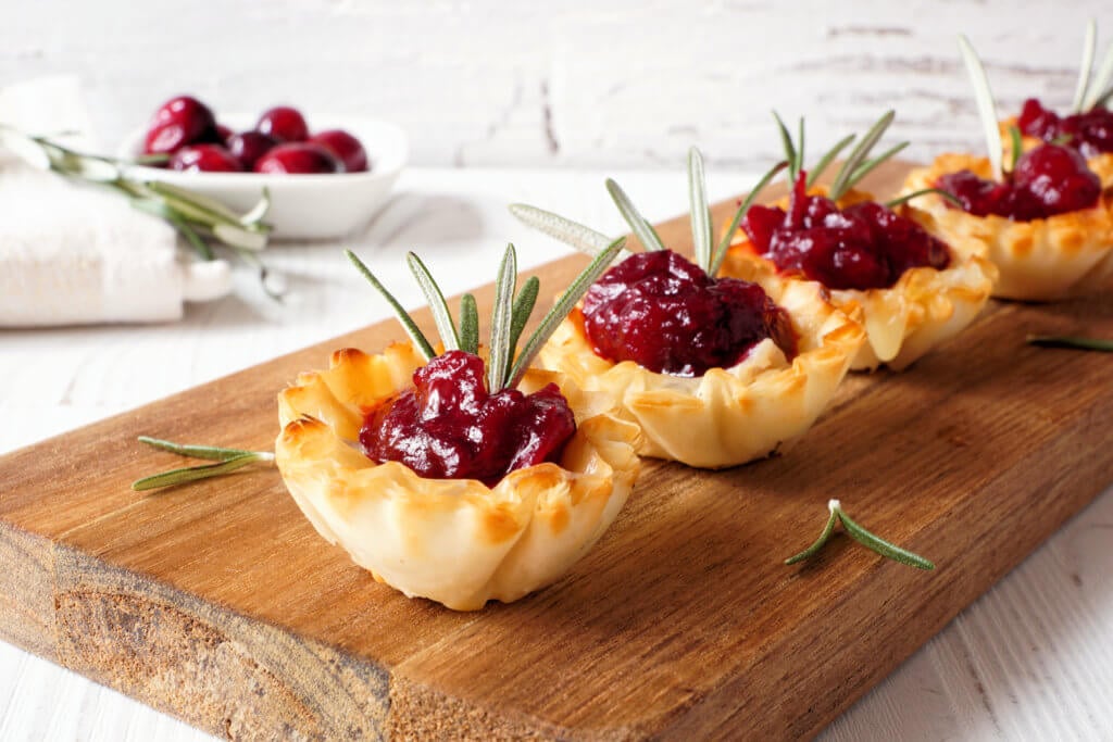 cranberry brie bites on a charcuterie board
