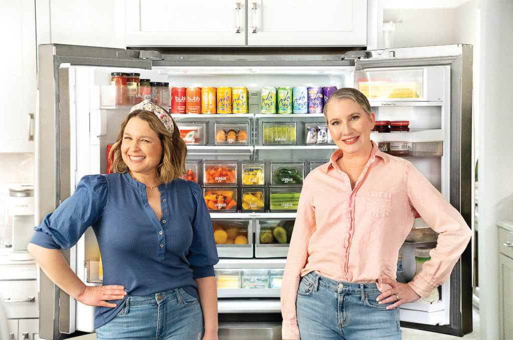 Clea and Joanna of The Home Edit standing in front of an organized fridge