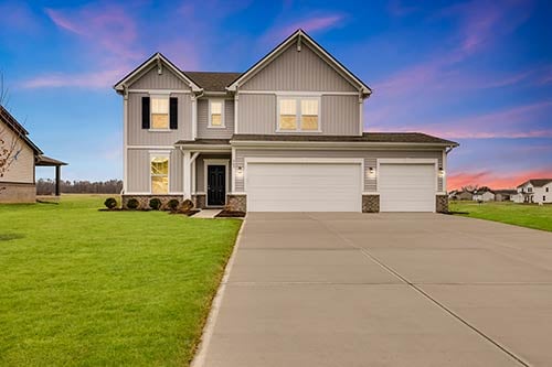 Exterior of Legacy 2670 featuring gray siding, 3-car garage, and manicured front lawn in Grand Oaks