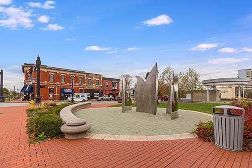 Public gathering space in downtown Mooresville with modern sculpture, shops, and walkable area