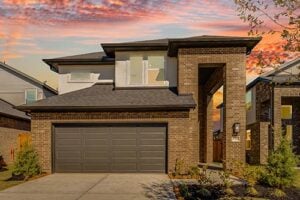 Sunset exterior of the Nantucket model with 5 bedrooms, brick façade, and modern elevation in Trillium