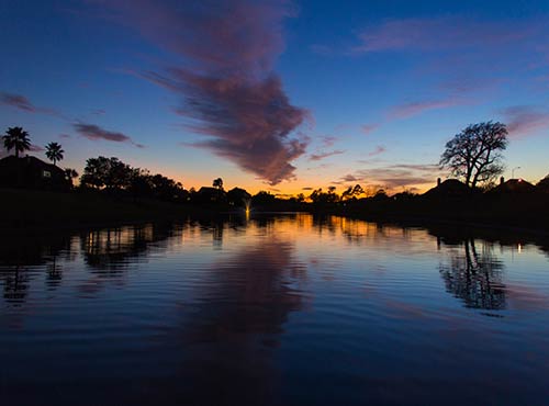 Tranquil lake in Tomball at sunset, reflecting a peaceful community environment for future homeowners